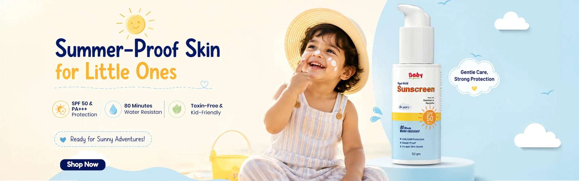 A happy toddler wearing a straw hat with sunscreen on their cheeks, sitting on a beach next to a bottle of BabyOrgano Ayurshild Sunscreen SPF 50, featuring 80 minutes of water resistance and toxin-free protection for kids.