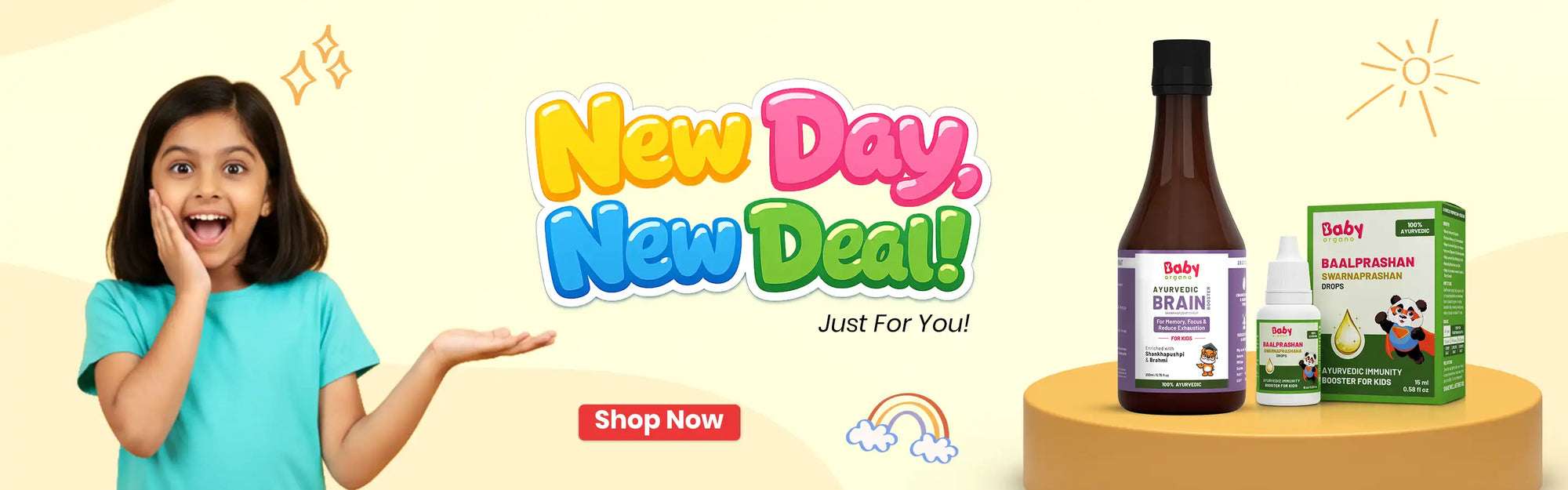 A vibrant "New Day, New Deal" promotional banner featuring a smiling young girl and Baby Organo Ayurvedic products, including Brain Booster syrup and Baalprashan drops.