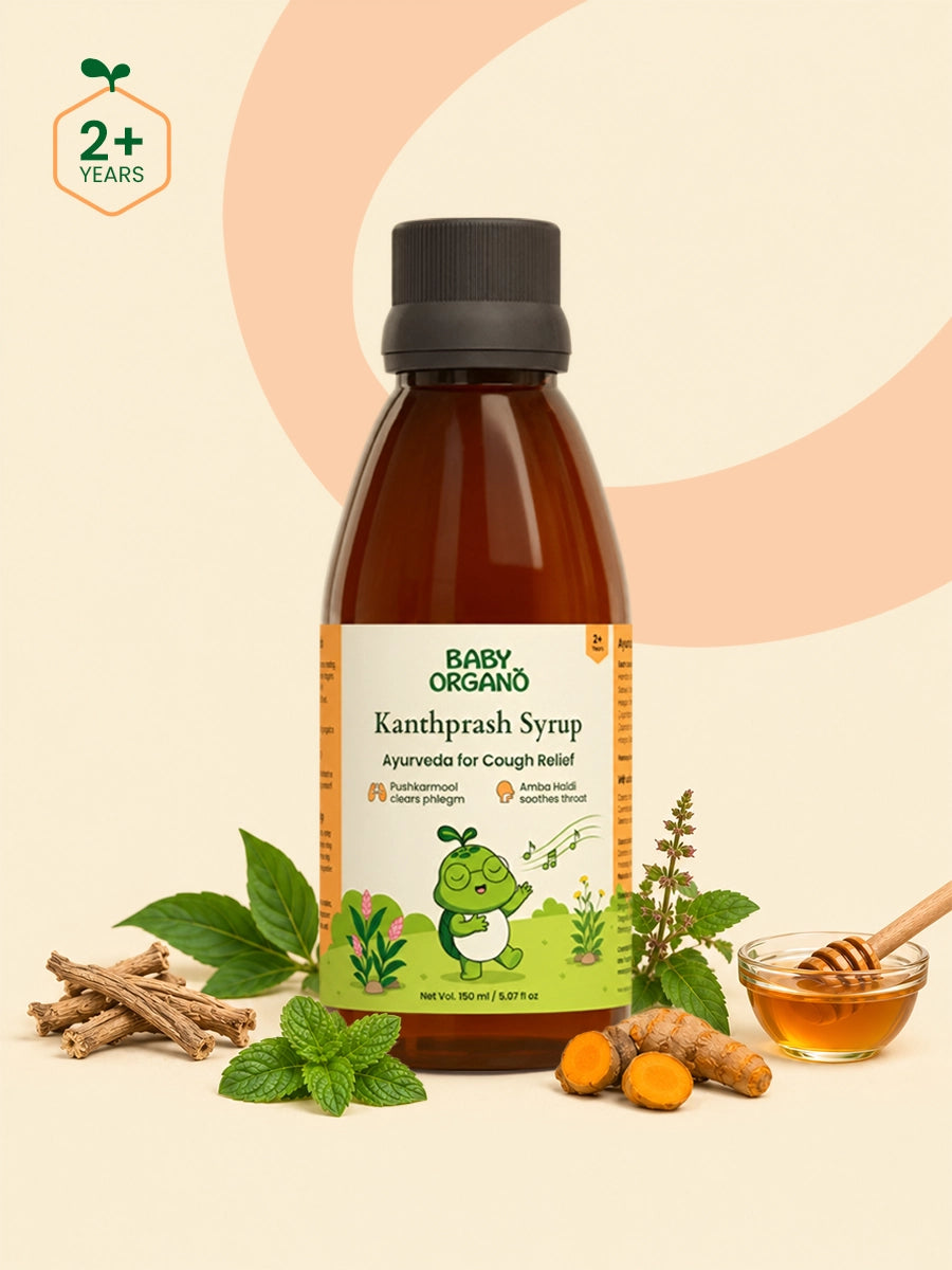BabyOrgano Kanthprash Syrup in an amber brown bottle with a black cap, displayed with herbal ingredients including mint leaves, turmeric root, cinnamon sticks, and a honey dipper on a beige background with a peach circular graphic.