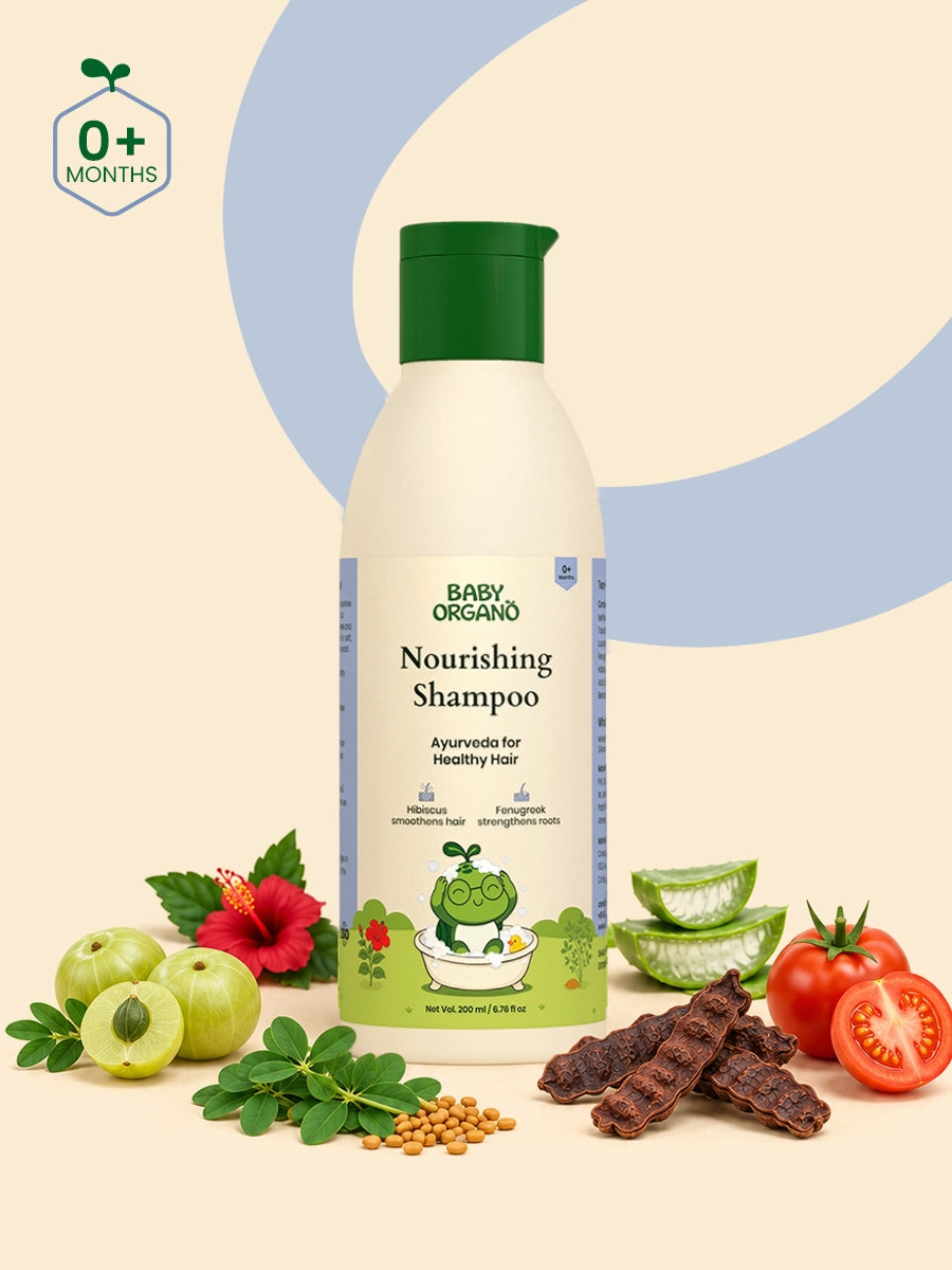 A bottle of BabyOrgano Nourishing Shampoo surrounded by natural ingredients including hibiscus, amla, shikakai, and fresh tomato.
