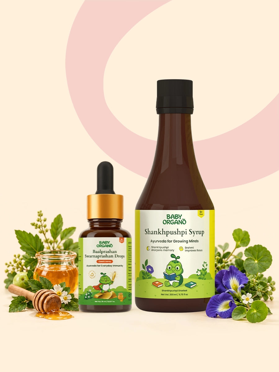 BabyOrgano Baalprashan Swarnaprashan Drops and Shankhpushpi Syrup bottles displayed alongside a jar of honey, honey dipper, and natural herbs.