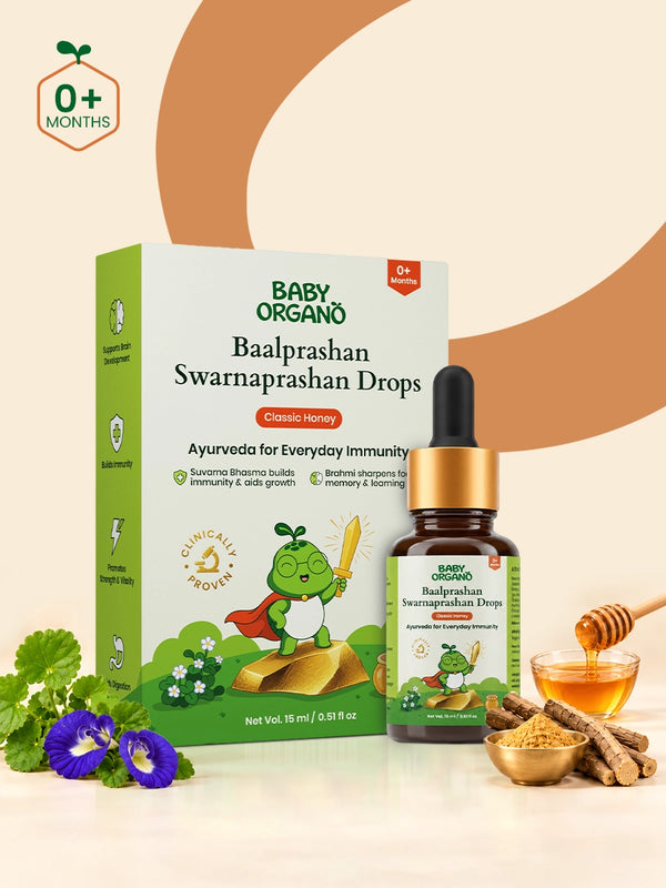 BabyOrgano Baalprashan Swarnaprashan Drops in a 15mL glass dropper bottle, styled with ayurvedic herbs, honey, and a honey dipper on a beige background with a brown circular graphic.
